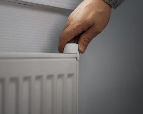 man-turning-off-radiator-during-energy-crisis